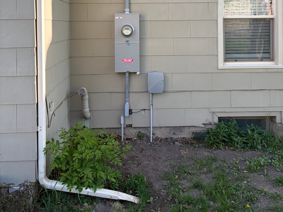 Meter socket and service disconnect panel installed on a home's exterior siding