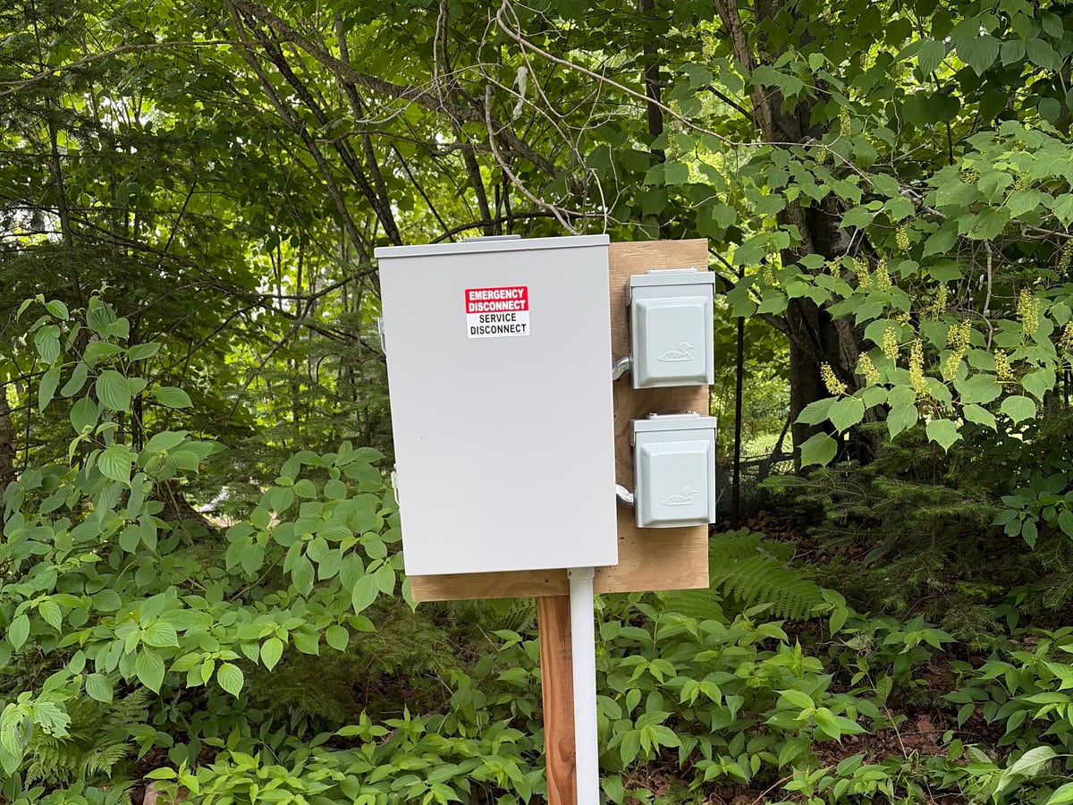 Outdoor RV and power pedestal with service disconnect and outlets installed on a rural Northern Minnesota property